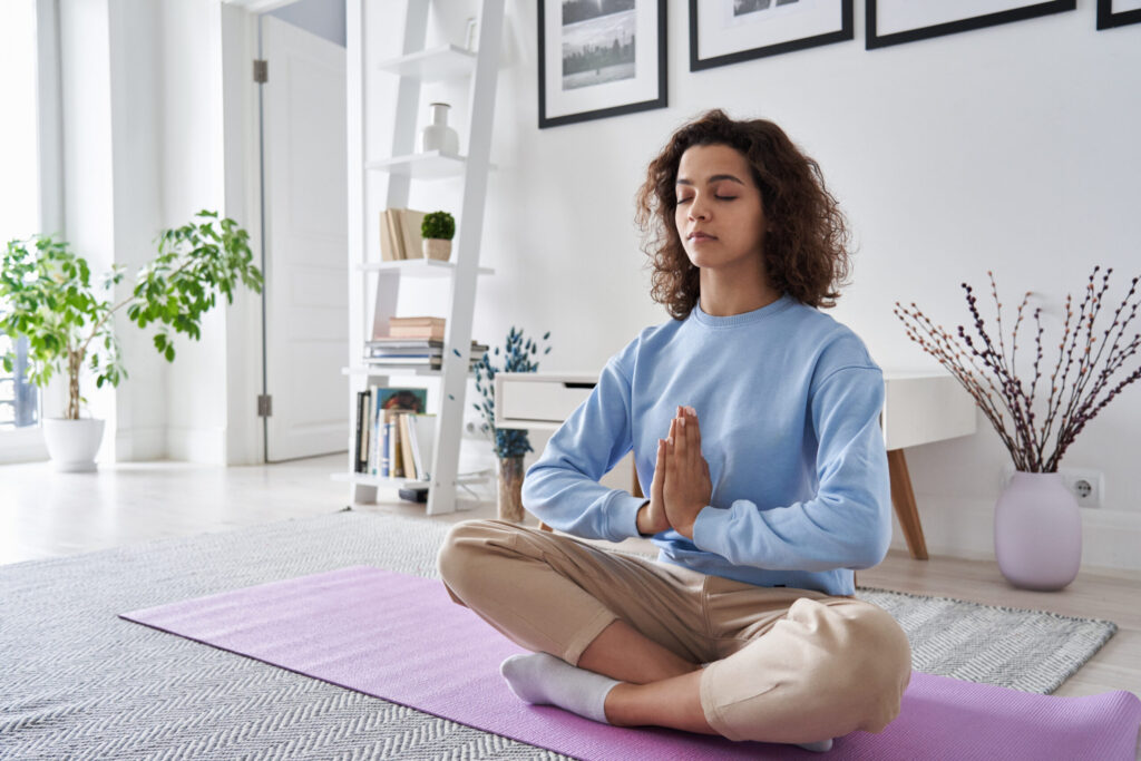 Woman meditating in her living room