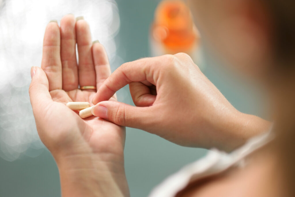 Close up view of young woman holding calcium supplements