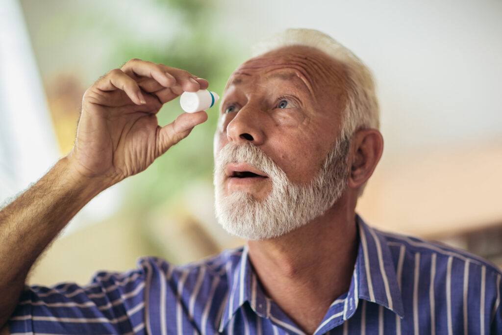 Elderly person using eye drops